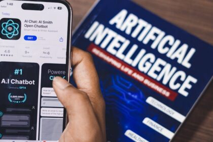 Smartphone displaying AI app with book on AI technology in background.